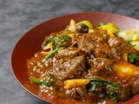 国産の牛スジ、ヤングコーン、ブロッコリー、広東白菜など9種類の野菜を自家製の麻辣醤で煮込んだ特製スープでいただく刀削麺です。2時間煮込んだ麻辣醤が麺とよく絡み、あと引く辛さが癖になる一品です。