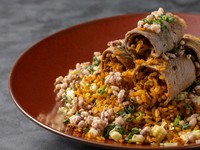 エリンギ、葉ニンニク、ヤングコーンが入った麻婆醤炒飯を、ハーブ牛サーロインで巻いてご提供いたします。上には五穀のおこげをまぶしており、食感と香ばしさが味のアクセントになり、食べ飽きない一品です。