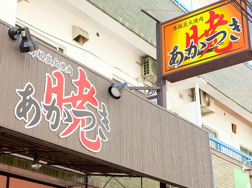 建物や空の色に映える、鮮やかな看板のカラー