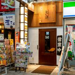 商店街の中、コンビニ横の横にある木製の扉からお入りください