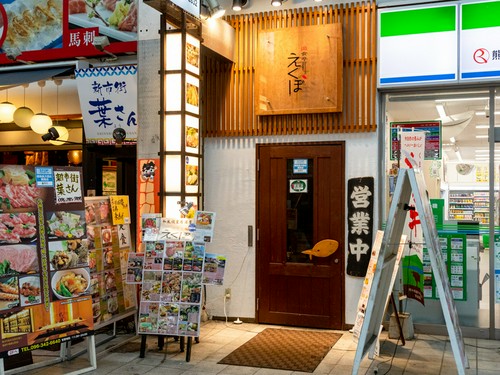 商店街の中、コンビニ横の横にある木製の扉からお入りください