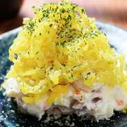 自家製のポテトサラダの上に、細かく刻んだたくあんを山盛りにしています。たくあんの塩みや旨みによって、ポテトサラダの味に奥行きを与えてくれます。