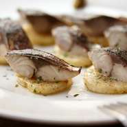 ソテーしたポテトに香ばしく炙った〆鯖をのせたシンプルなひと皿は、ワインに欠かせない定番メニュー