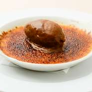 表面はパリッと香ばしく、中はトロトロの『アマレット風味のクレームブリュレ　キャラメルアイスクリーム』。甘さと苦味のハーモニーが、女性のみならず甘いものが苦手な男性からも高評価を受ける理由の一つです。
