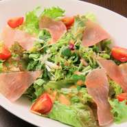 生ハム、トマト、香味野菜のシンプルな王道サラダ。濃厚なドレッシングをかけて。