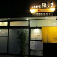 【日本料理　福しま】の暖簾と可愛い植栽がお迎えします。