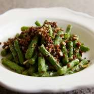 素揚げにしたインゲンと「芽菜」という四川省の漬物を炒め、甜麺醤ベースの肉味噌を添えた一品。