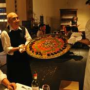 名物料理は40人前の大鍋パエリア。炊きあがりの鐘の合図で、鍋を抱えたスタッフが店内を駆け巡ります。