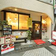 衣笠商店街にあるお店は、赤い看板が目印。大きな窓は開放感があり、１人でも気軽に入れる雰囲気です。