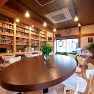 壁一面の本棚に大きなテーブルが図書館のような居心地のよさを醸し出しています。本棚に設置されたライティングデスクは、読書はもちろん、しばしの勉強タイムにも利用できます。