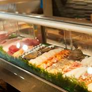輝くほどに活きのいい鮮魚が並ぶ、カウンター前のショーケースに注目。ネタの良さを見てもらいたいという自信の表れです。もちろんお客が見て、好みの魚を注文することもできます。