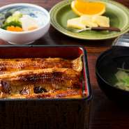 鰻重だけでなく、吸物、香の物、果物も並ぶ定食スタイル。米は茨城産のコシヒカリを使用しています。