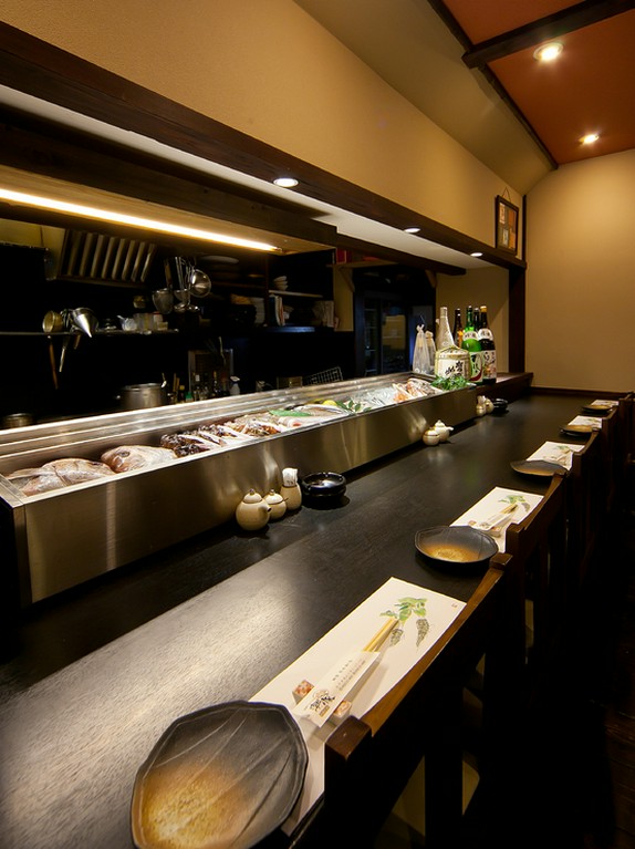 料理人の手つきに見とれるカウンター席