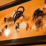 テーブル席の脇に飾られた鶏の絵画は、オープン当時に東京食鳥組合の会長から送られたもの。