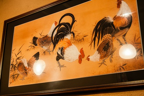 シンプルな店内で存在感を示す鶏の絵画