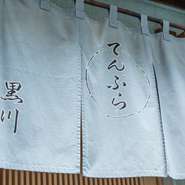 築地場外の路地裏にひっそり佇む、大人の隠れ家が【てんぷら　黒川】です。毎朝、ご主人自らが築地に赴き仕入れする鮮魚と千葉の契約農家より直送される野菜を、極上の天ぷらで味あわせてくれます。
