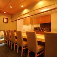 寿司屋には珍しく、背もたれの高いダイニング用の椅子を並べ、その高さに合わせてカウンターを設置。