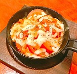 トマト丸ごと一つを、アツアツの鉄板で焼きました。　オリジナルソースとチーズの相性も抜群です！