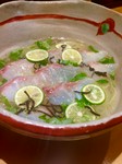 鯛の出汁と鶏がらの澄んだ旨みのあるスープに鯛の昆布締め刺しとすだちを並べた温そうめん
