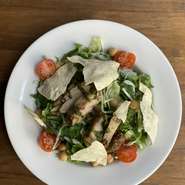 グリーンサラダの上にスパイスの効いたグリルチキンとパリパリパパドをトッピング！