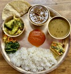 ダル（スープ）、バート（ご飯）、タルカリ（おかず）、アツァール（漬物）にチキンカレーが付くプレート。