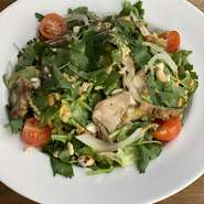 コリアンダーリーフにチキンとクラッシュナッツをトッピング。オリジナルドレッシングで！