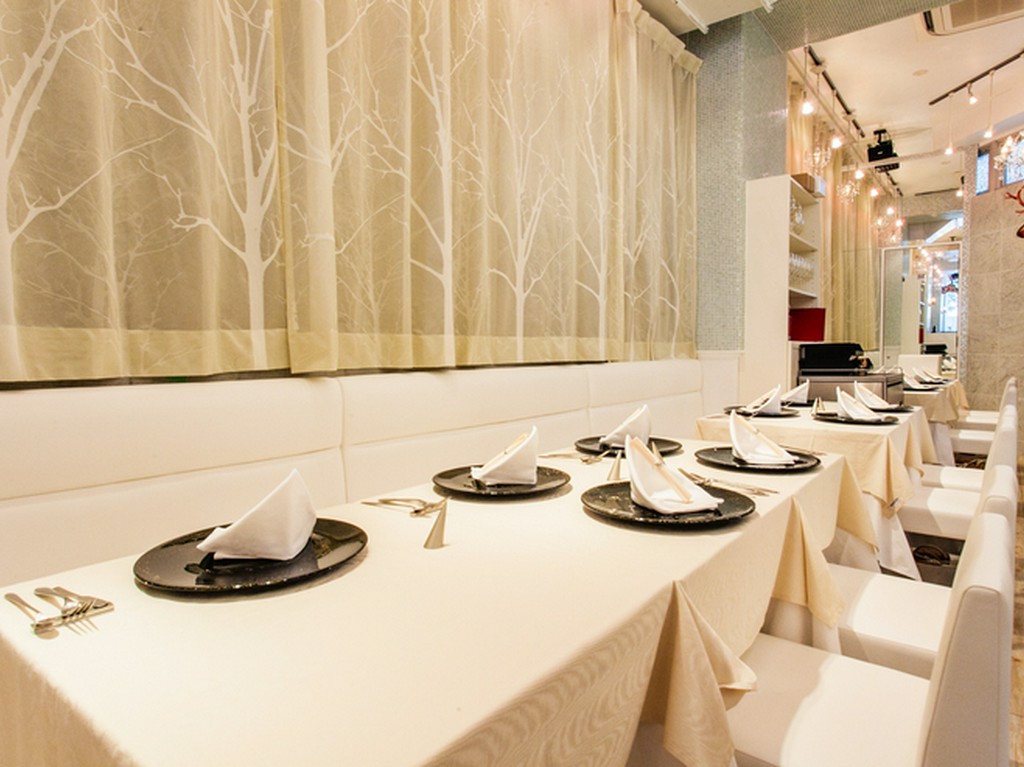 オープンキッチンから厨房の熱気が伝わるテーブル席