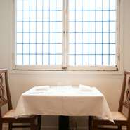 ６卓のみのこぢんまりとした店内は、白塗りの壁でシンプルなテイスト。アンティークの窓枠やイタリア製の椅子で揃えた、落ち着いた空間になっています。