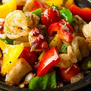 新鮮なシーフードを香味野菜や多彩なスパイスとともに炒めた逸品。ニンニクの香りが食欲を刺激します。