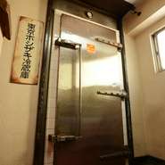 料理に自信があるからこそ、あえて看板を出さず、隠れ家的な雰囲気を大切にしています。ビルの２階に上がると「冷蔵庫のドア」があります。これが入口。秘密基地を見つける気分で探してみて下さい。