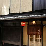 店の外観は、祇園の町並みに溶け込んだ風情あふれる京町家。引き戸にかけられた臙脂色の暖簾と、小さな提灯が目印です。