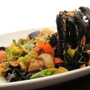 いかすみ入りの黒いパスタにからんだ、北海道産の毛ガニと香り野菜のソースが絶品です。