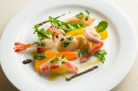 新鮮なボタンエビやホタテなど、旬の魚介が6種類ほど。季節の野菜と合わせた、やさしい色合いの一皿です。
