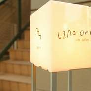 表参道からキャットストリートに入って250ｍほど行ったところにある建物の2階。通り沿いに目立った装飾はなく、入口付近にあるロゴの描かれた丸看板が目印です。