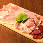 生ハムとサラミの盛り合わせです。ハモンセラーノ、プロシュート、シュペック、コッパ、ロンガニーザ、ボロニアハム、ドライサラミ等、その日のおススメを盛合せでご提供致します。/ハーフサイズ880円