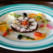 シェフのスペシャリテ。横須賀佐島の活けダコ使用。ゼラチンを加えず、タコのぬめりを利用して固めたサラミは、お口の中でほろりと崩れます。地中海をイメージするブルーのお皿で。