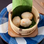 蒸篭のふたを開けると海老の香りがふわりと立ち上る蒸し物。その時期に一番いい海老を食感が残るように粗めにたたき、シンプルに蒸し上げます。春は木の芽、秋は菊花など季節の香りを感じるつけだれを添えて。