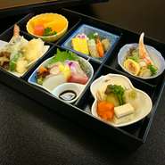焼物八寸、お造り、焚き合せ、油物、酢の物、水物　※別途御飯付き（216円税込）もご用意出来ます
季節や仕入れの都合により内容が一部変わる場合が
ございます
※器は後日引き取りに伺います