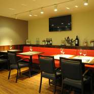 暖色の明かりで落ち着いた雰囲気を持った店内。テーブル席は、それぞれの席の間にゆとりをもたせておりますので、ゆっくりとワインと料理を楽しみながらお過ごしいただけます。