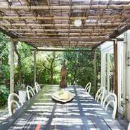 庭のグリーンが気持ちいいテラス席。テーブルの中央には野菜が天日干しされています。