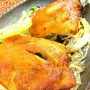 骨付きチキンの串焼き。個性的なネパールアイスビールなどのお酒との相性も抜群のメニューです。