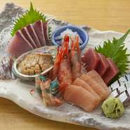 毎朝、店主自ら高岡水産物市場で仕入れる旬の魚介7～8種類がひと皿に。写真は白エビ、マグロ、ブリなど。