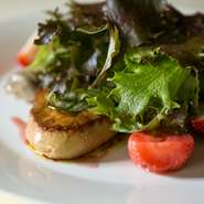 ソテーしたフォアグラに旬のフルーツとコンフィ、屋上菜園の野菜を合わせ、黒胡椒風味のカラメルソースを。