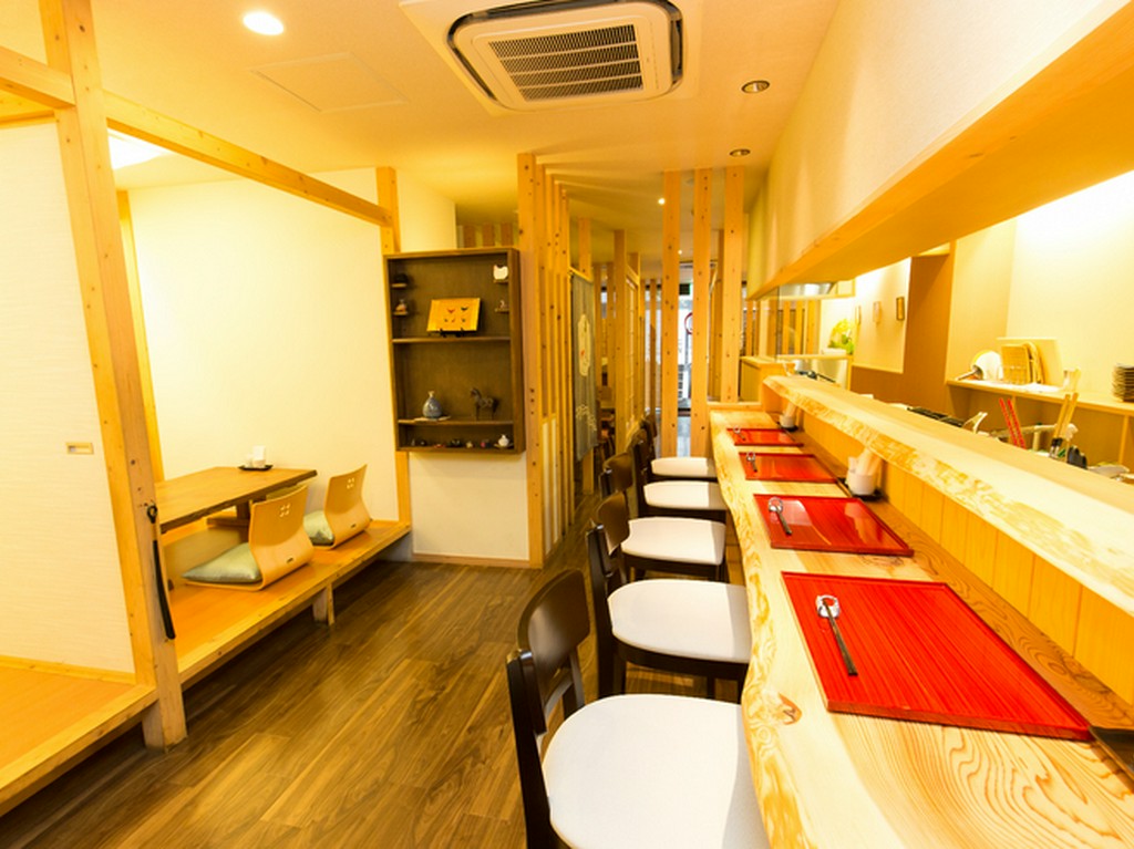 杉の木の一枚板のカウンター、漆の茶碗など、温かみのある素材