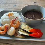 鉄板で香ばしくローストした新鮮な海老と帆立てをこだわりの黒カレーと一緒に。