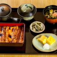 江戸前の煮あなごをたれでつけやきにし、お重にてお出ししています。柔らかく仕上がった身と甘辛いたれはご飯との相性も抜群です