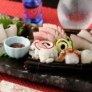 いろいろな旬の魚を一皿に盛合せて。なるべく天然のものを使用している『お造り　盛合せ』。美しく彩られた新鮮なネタを存分に楽しむことができます。日によって替わる内容も楽しみの一つです。日本酒と一緒に。