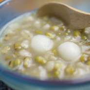 沖縄で夏に食べられる冷たいお粥状のぜんざいのような伝統菓子『あまがし』。緑豆と平麦を半分ずつ使い、子供の健やかな成長を願い作られたおやつです。観光の合間に、ちょっと一服してみませんか？