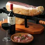 オーダーのたびにブロック肉から切り出して提供するパルマ産プロシュートは、ワインのお供の定番メニュー。