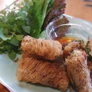 編目の春巻の皮で海老や豚肉を包んで揚げた人気の一品。パリパリの食感と香ばしさは、やみつきになります。さっぱりとした甘酢タレでハーブと野菜に巻いてお召し上がり下さい。
